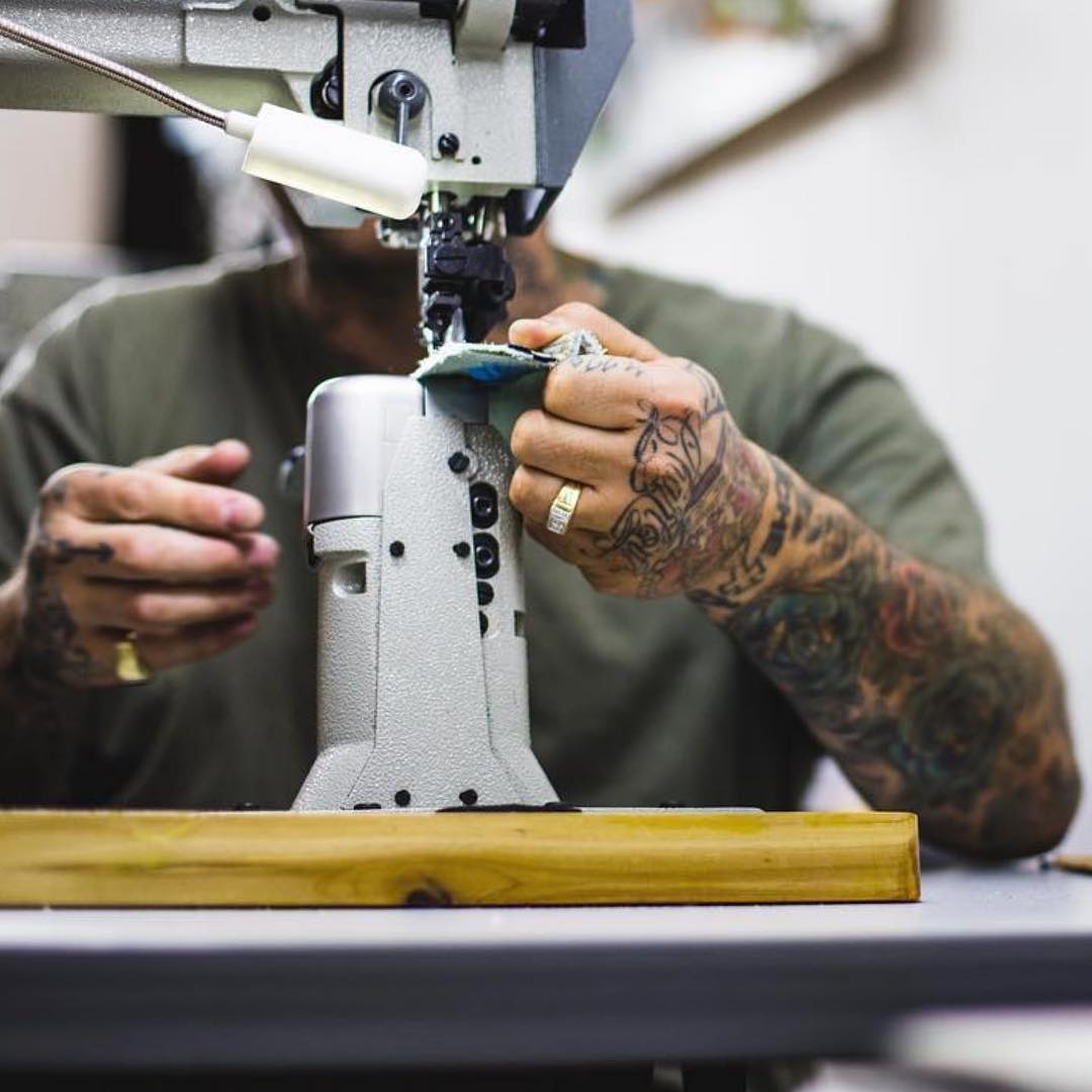 Photo of a man working on a shoemaking machine who is wearing a ring