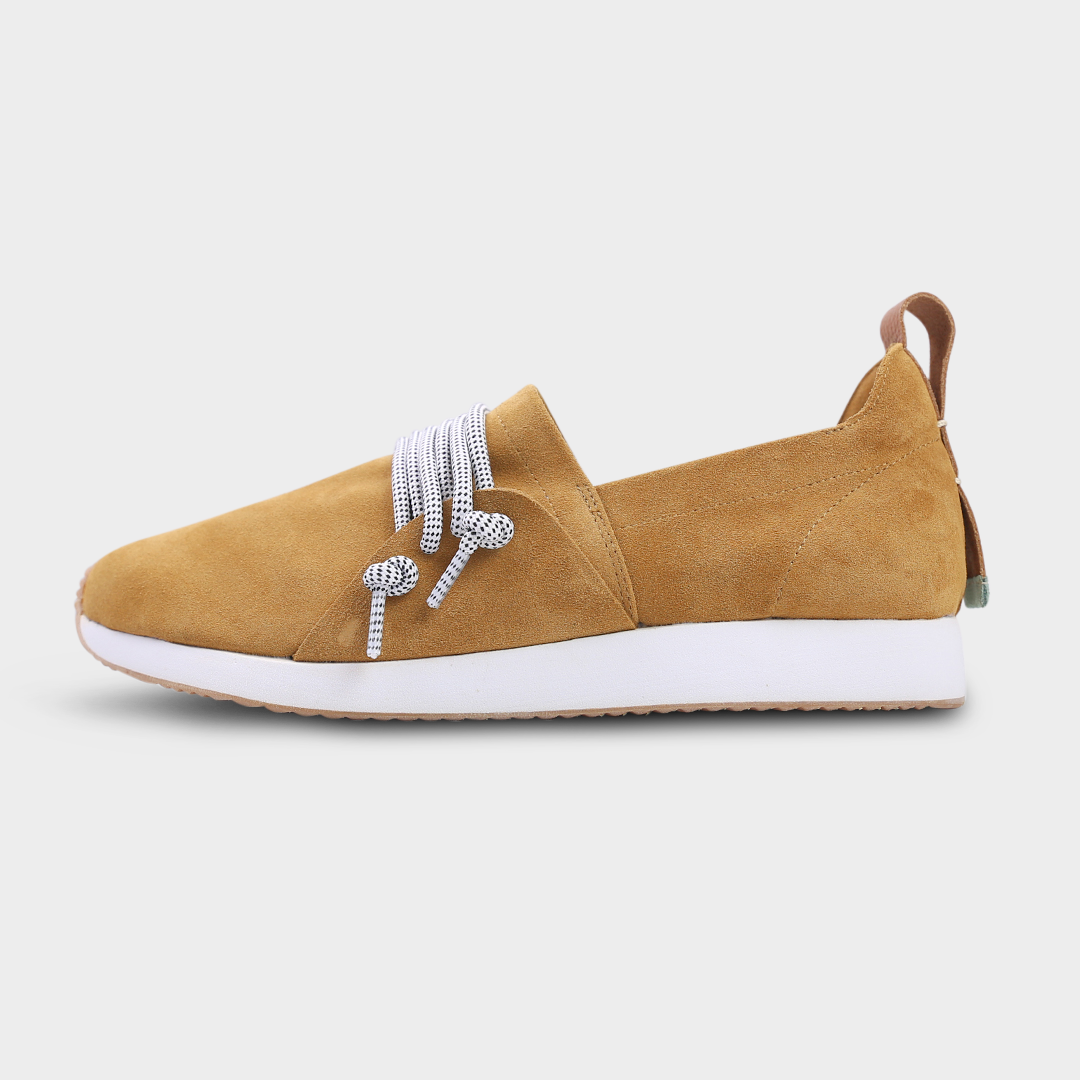 A profile picture of a brown suede COMUNITYmade Mateo sneaker with a white sole and lace-up closure, white midsole and gum rubber outsole and a leather heel loop pull tab
